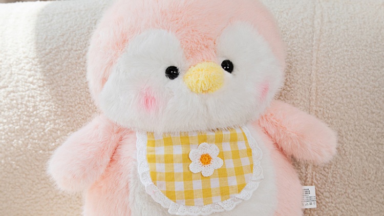 Pink and white penguin plush doll wearing yellow plaid clothes