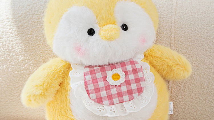 Yellow and white penguin plush doll wearing red plaid clothes