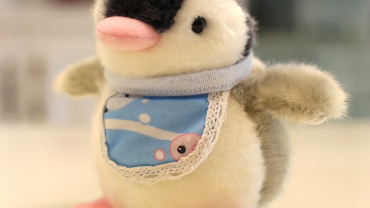 Penguin plush doll wearing bib